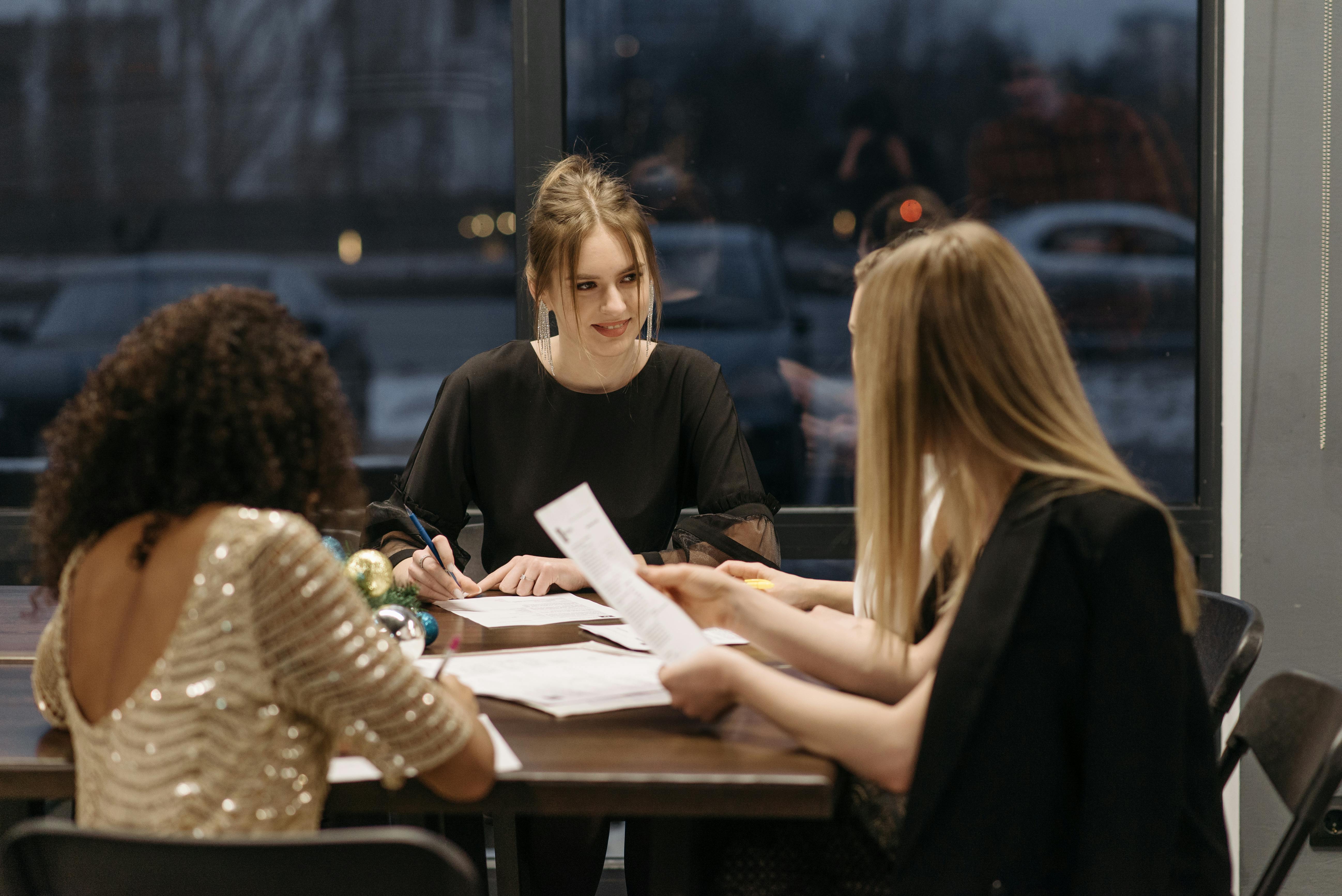 A group of women sitting around a table, negotiating a deal